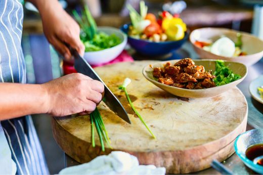 Hands chopping fresh herbs during a Greek cooking experience